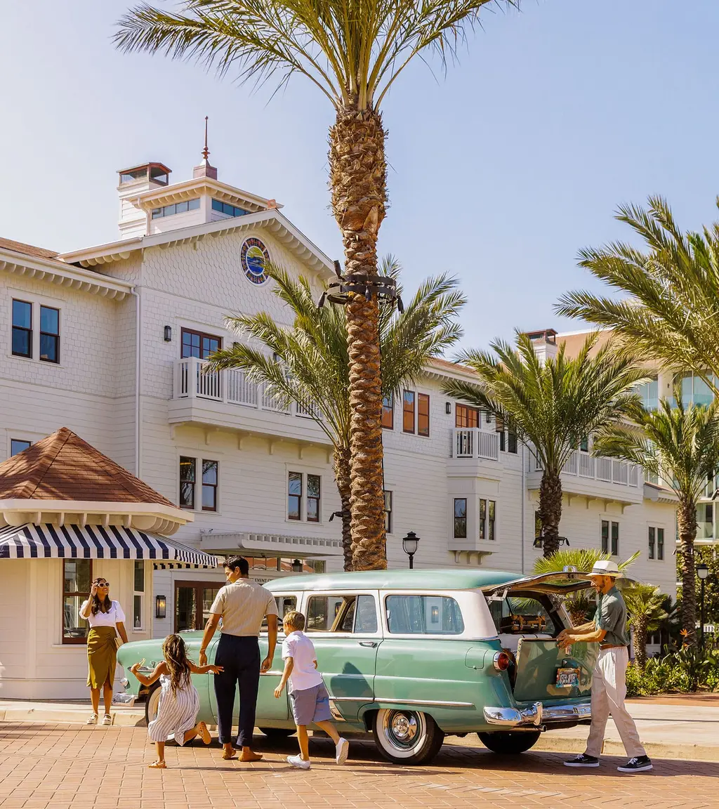 A family beside a vintage car at the Shore House entrance