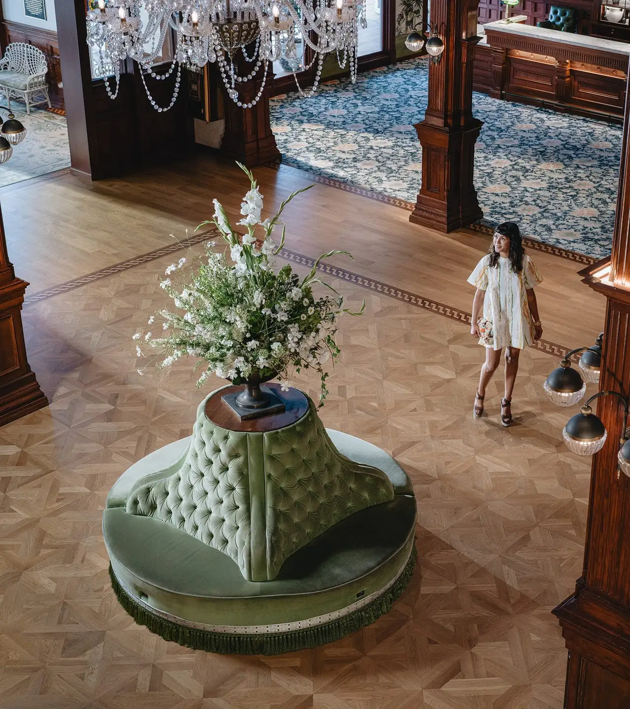 A woman crosses the Victorian lobby, seen from above