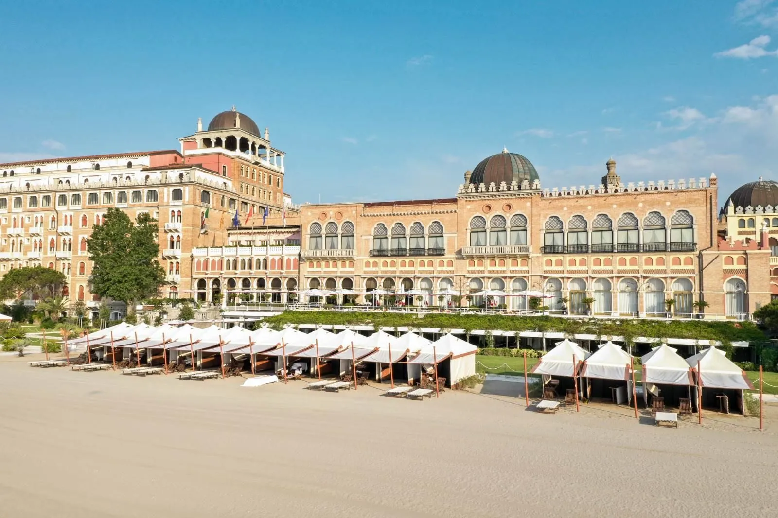 The hotel’s Moorish façade from the sand, with its domes, arched windows and white cabanas lined up on the empty beach.
