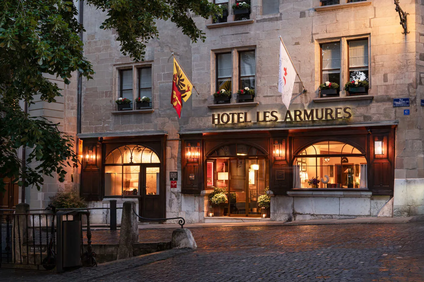The hotel façade with its flags, at twilight
