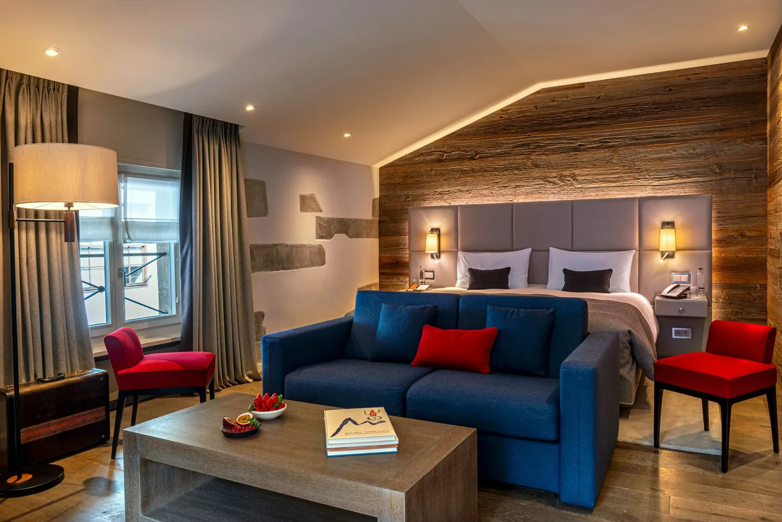 A Junior Suite with its wooden wall and blue sofa