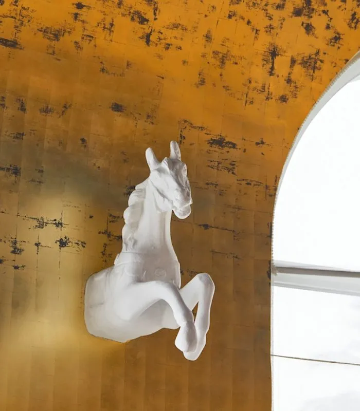 La scultura di un cavallo bianco sulla parete dorata della Rotonde