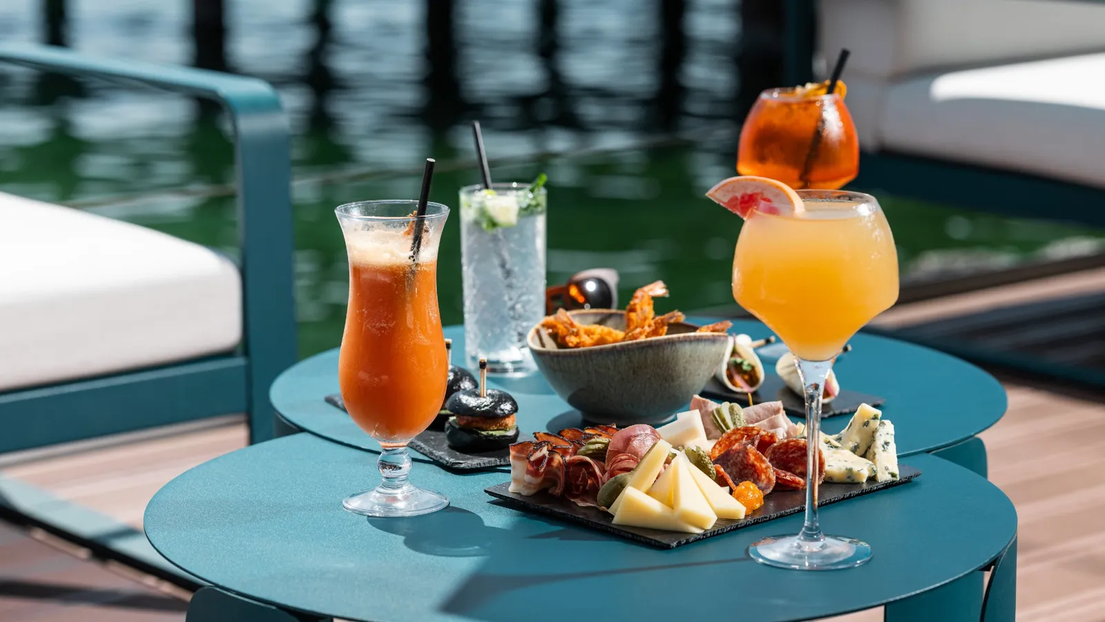 Cocktails and sharing boards on a Summer Bay table above the water