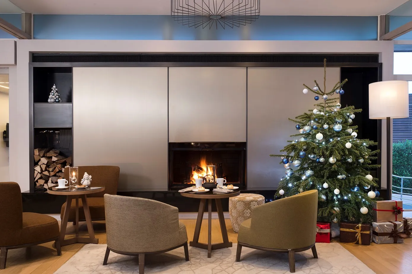Le Cadran armchairs in front of the lit fireplace