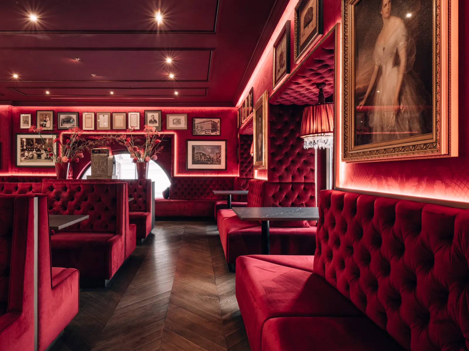 Café Bel Étage: booths in buttoned red velvet, framed photographs and a large portrait of a woman on the wall.