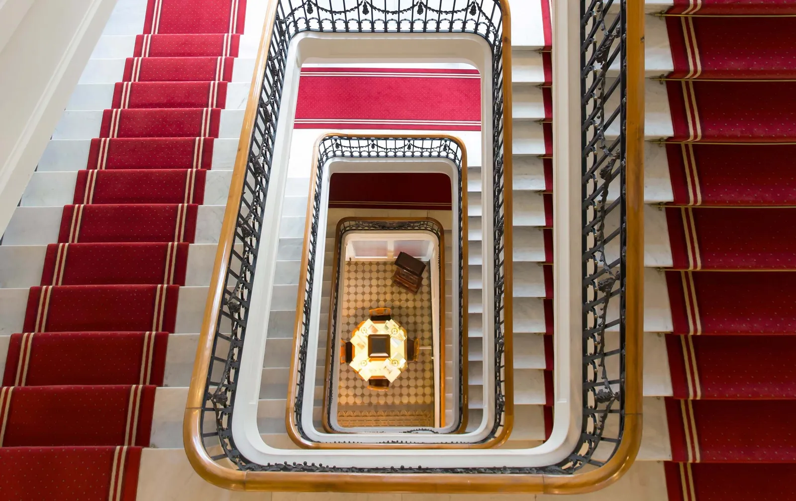 La scala dello Schweizerhof con la passatoia rossa