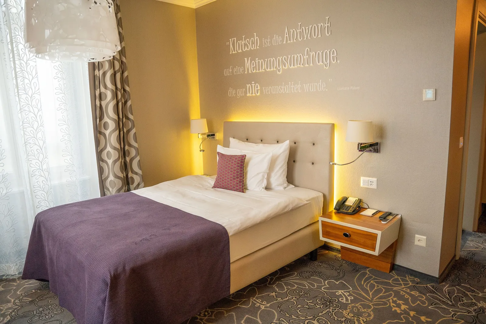 Una Style Single Room con letto singolo e parete scritta