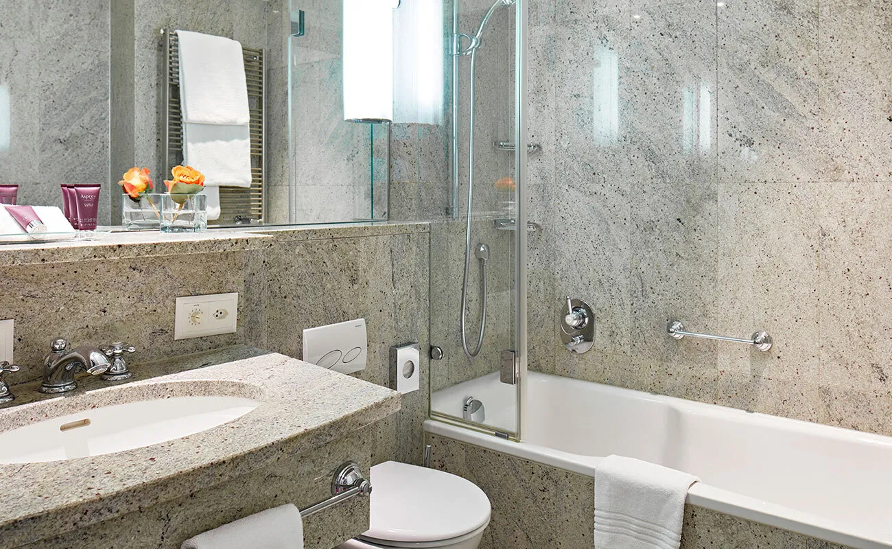 A bathtub and washbasin in a hotel bathroom