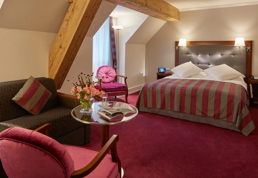 Bed and sofa in a Dufour Deluxe Room