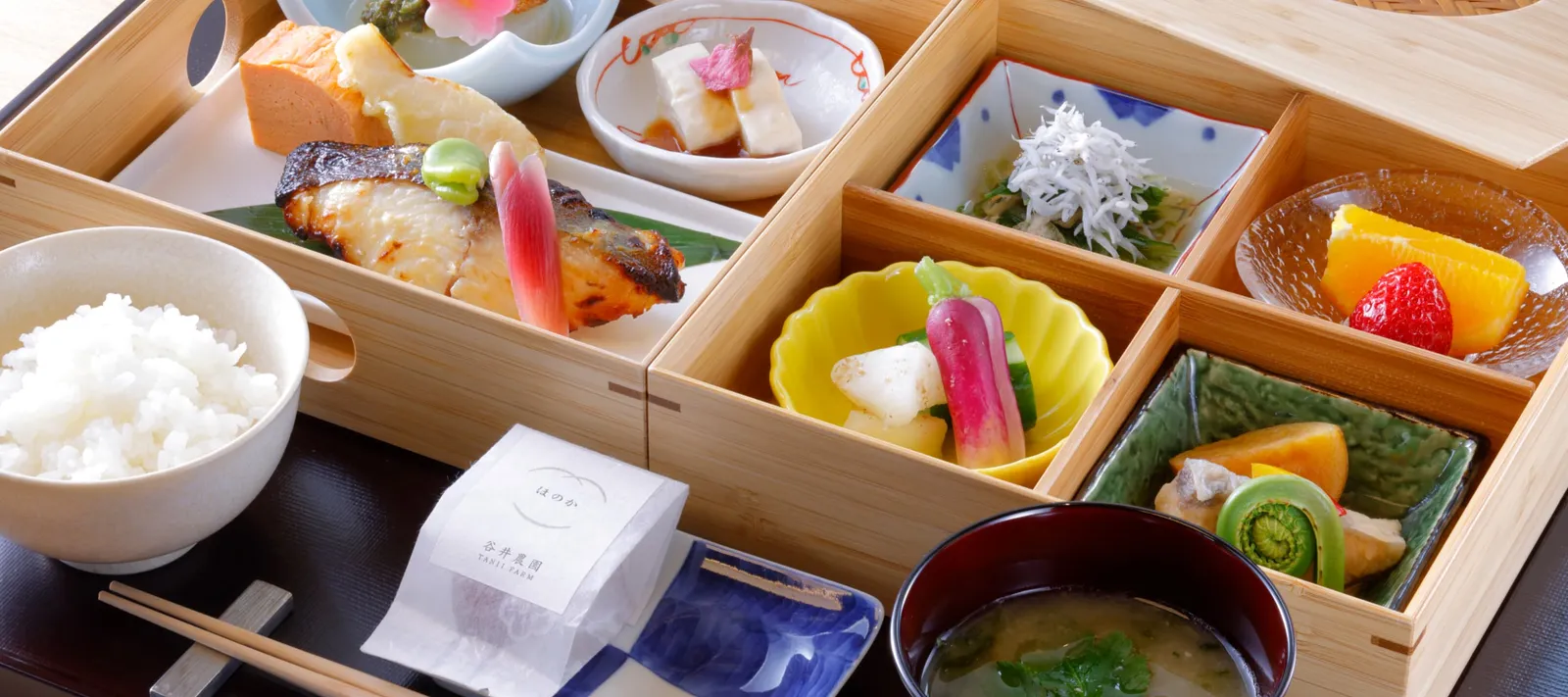 The Japanese breakfast in its oju box: grilled fish, vegetables, dashimaki omelette, white rice and miso soup.