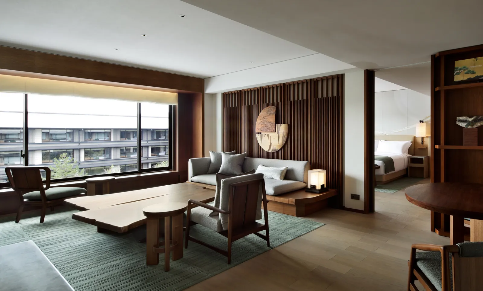 A Garden Suite’s living room: sofa and armchairs around the wooden table, and the windows onto the garden.