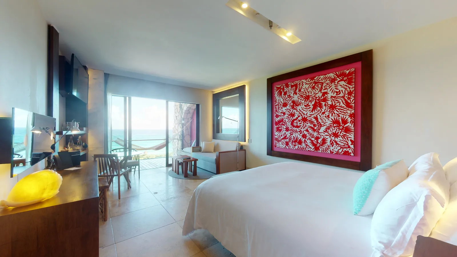 Ocean Front Adults Suite with bed, balcony and sea beyond the glass door