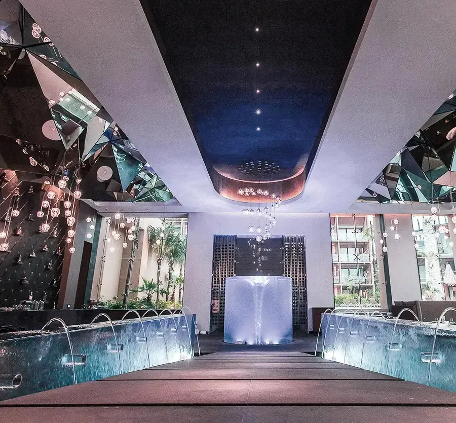 The dining room at HA’, with pools of water on either side and hanging lights