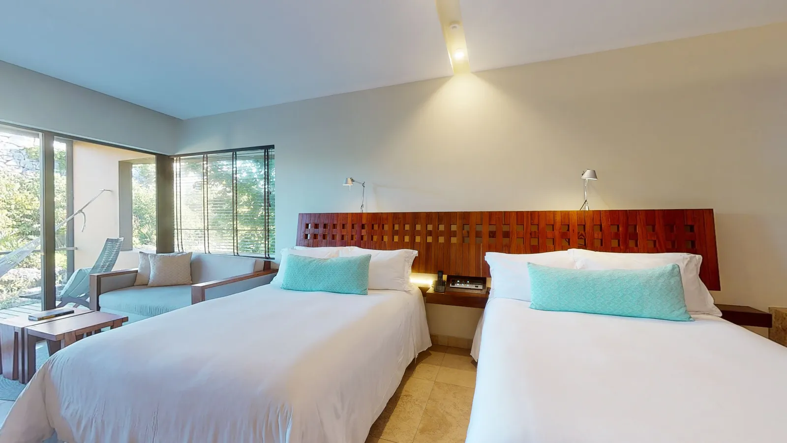 River Suite with 2 beds and a seating area beside the terrace