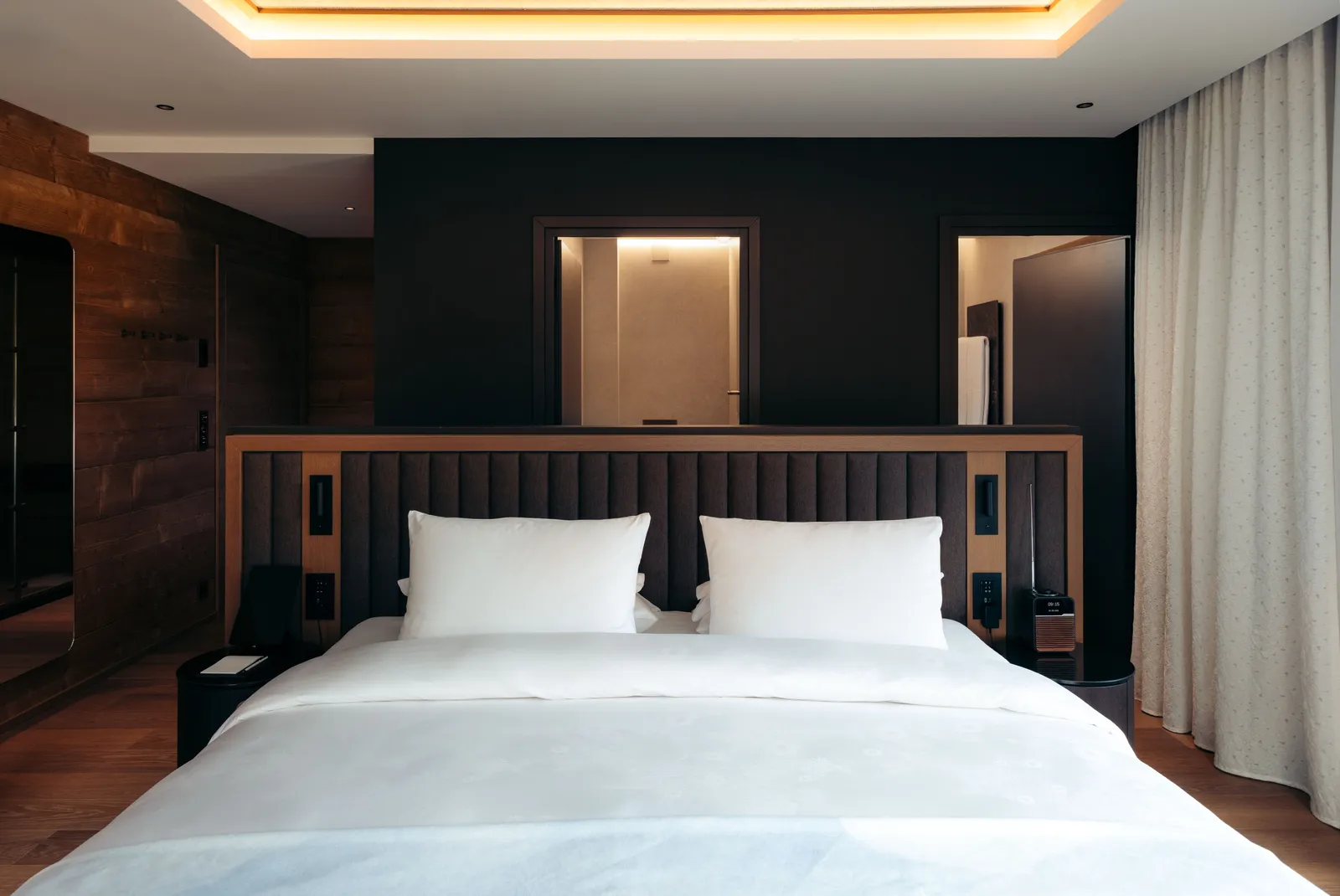 Il letto della Deluxe Double King davanti alla parete scura