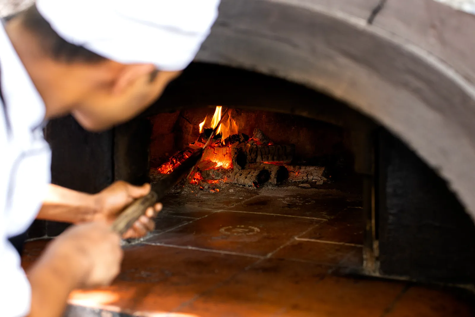 Fogliani’s wood-fired oven, a cook sliding in a pizza