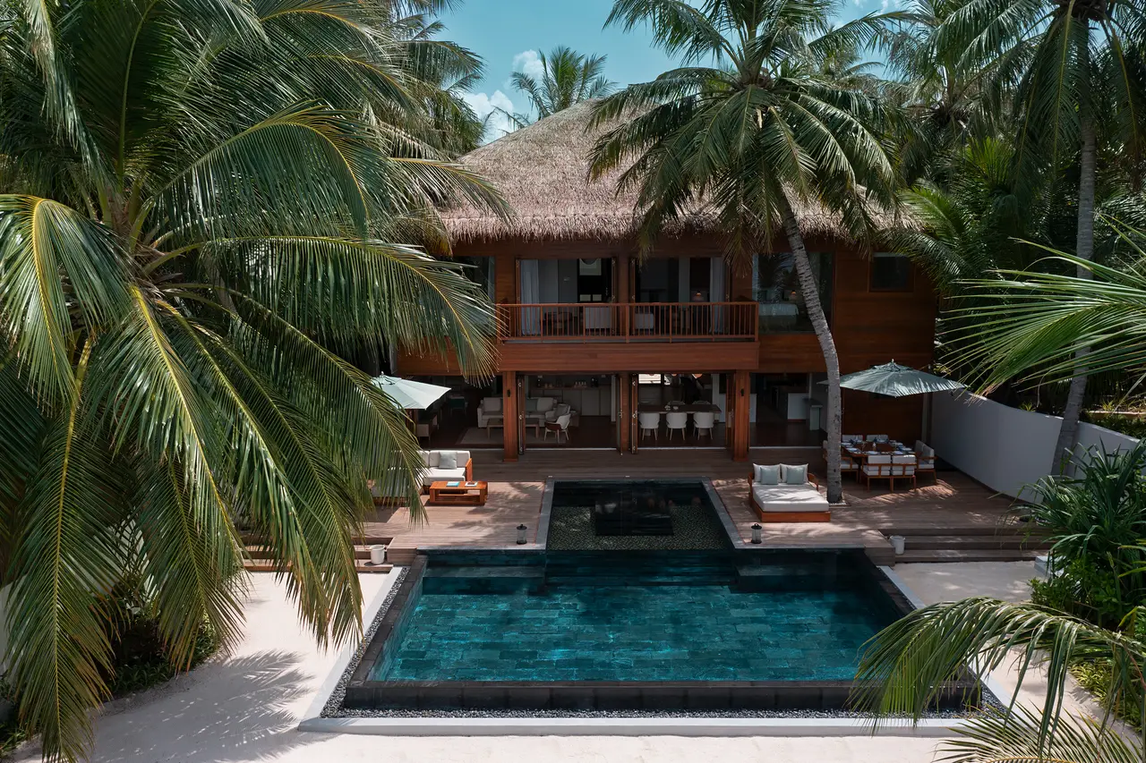 The Beach House from above, the 2-storey house and its pool among the palms