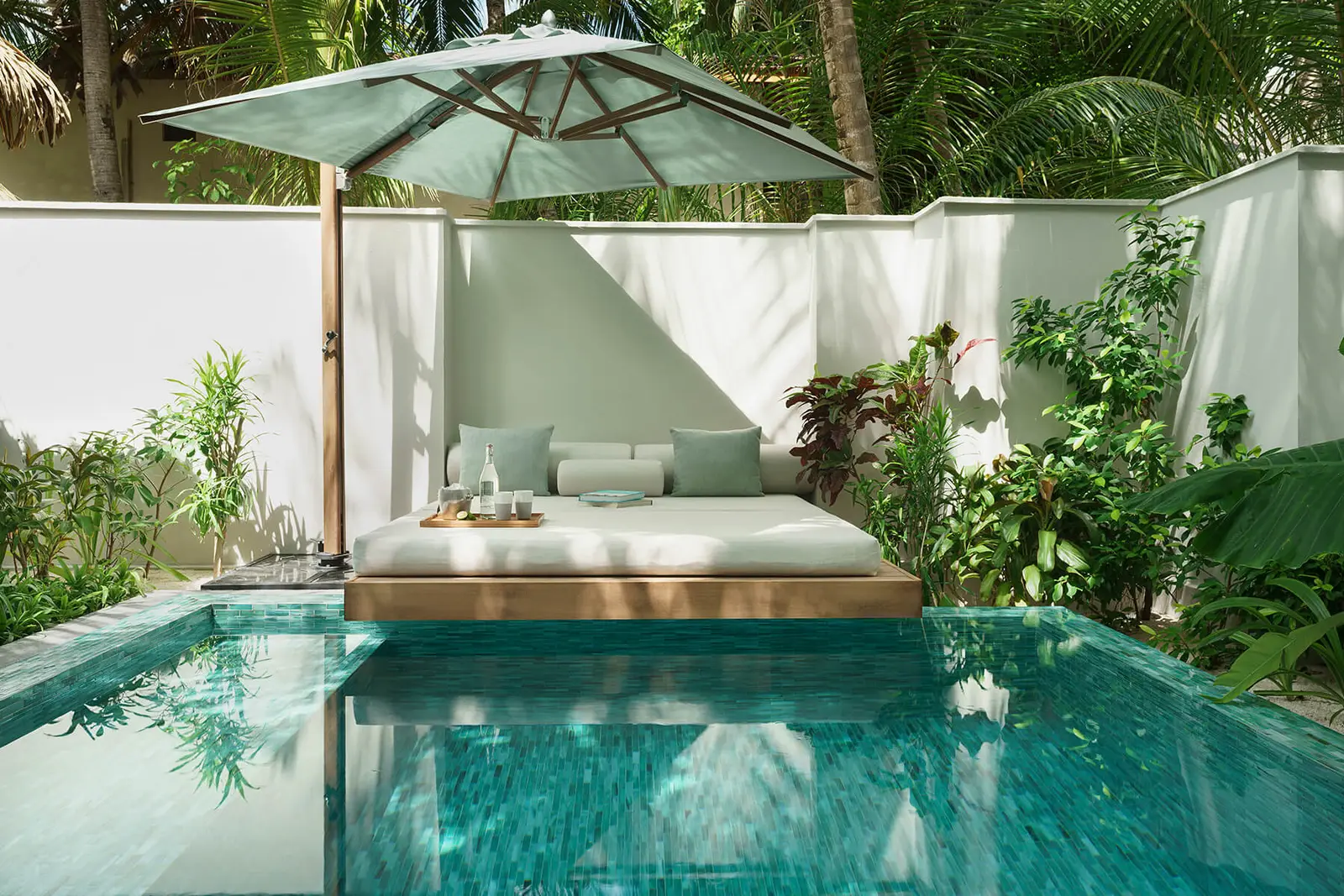 A Deluxe Beach Bungalow’s courtyard: the pool and the daybed under its parasol
