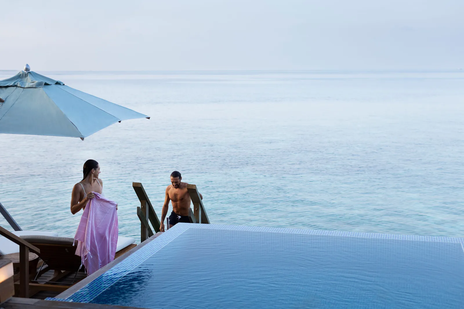 2 guests in an Ocean Bungalow’s infinity pool, the ocean ahead