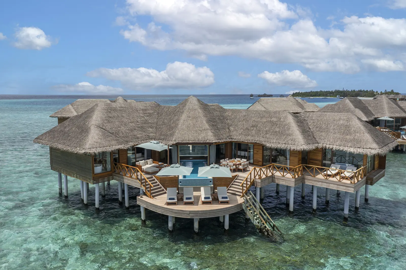 The Two-Bedroom Ocean Pavilion over the water, its decks and pool