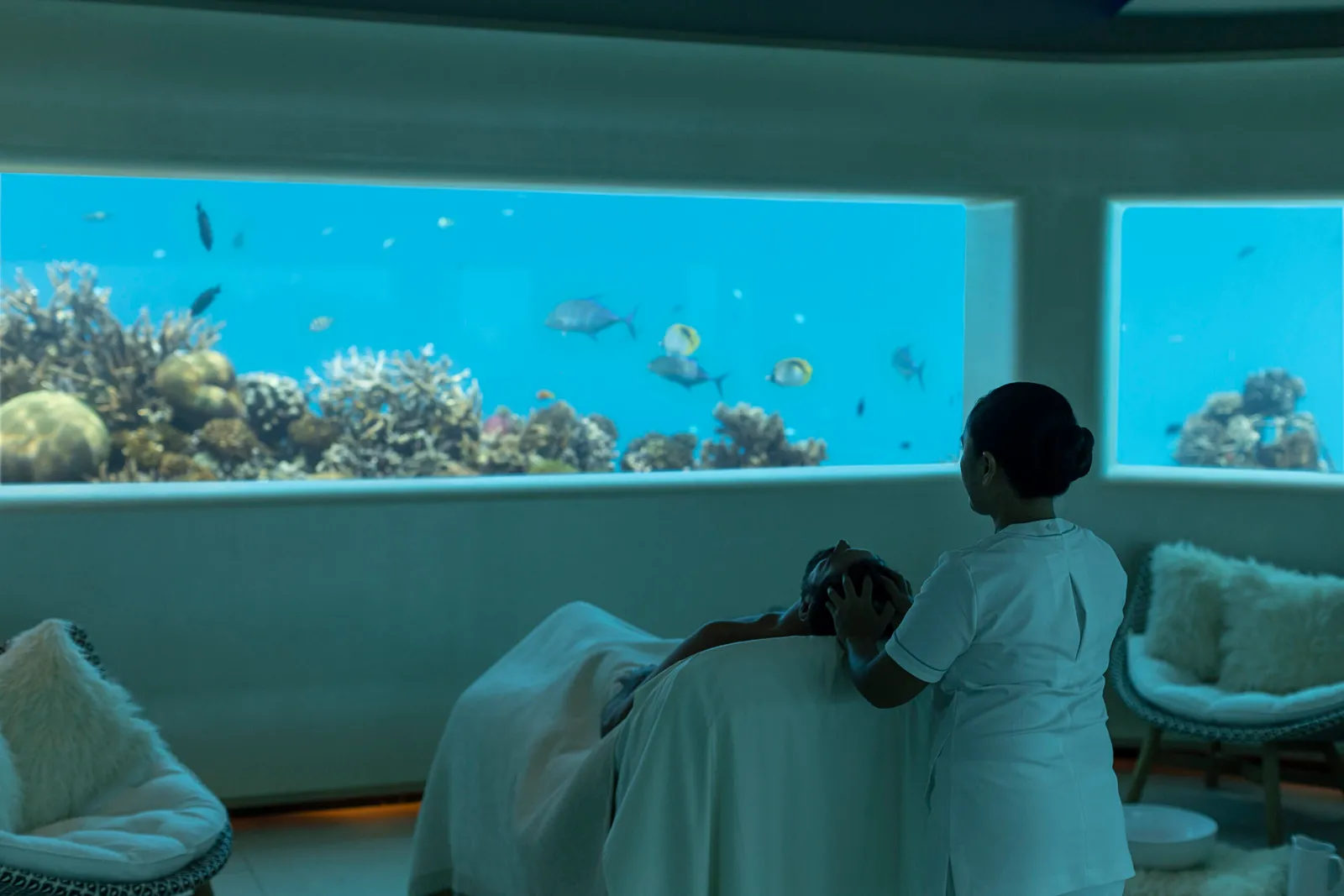 A treatment in the underwater spa room, the reef and its fish beyond the glass