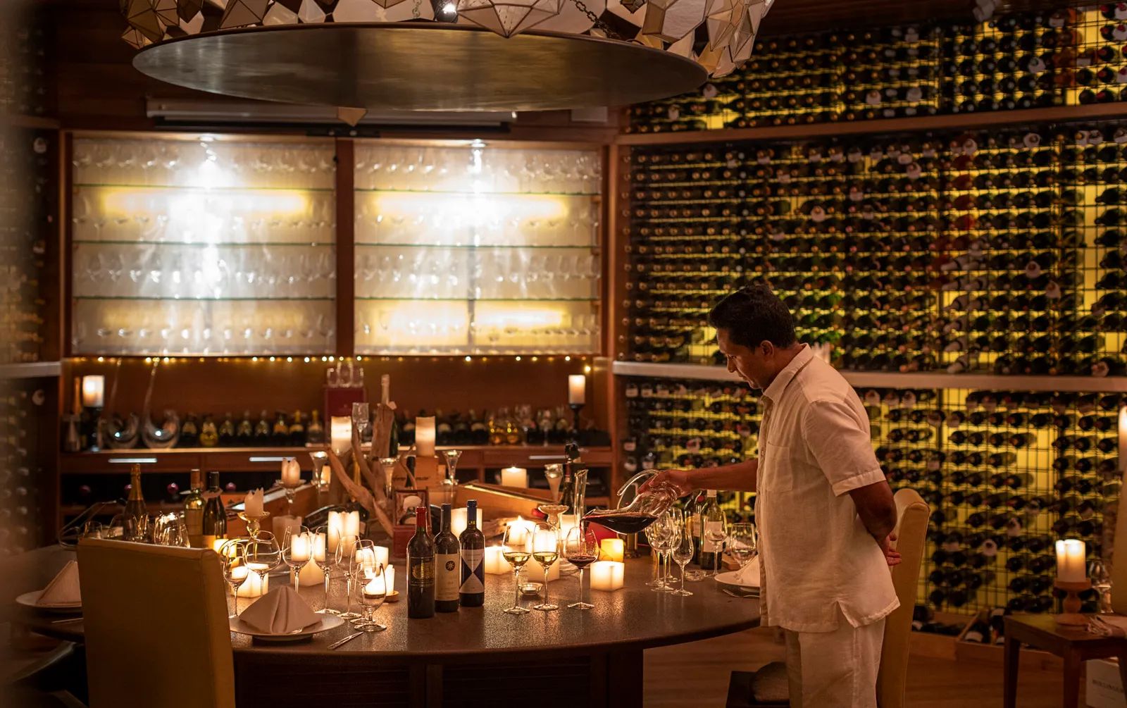 Vinum, the underground cellar: the table laid and walls of bottles