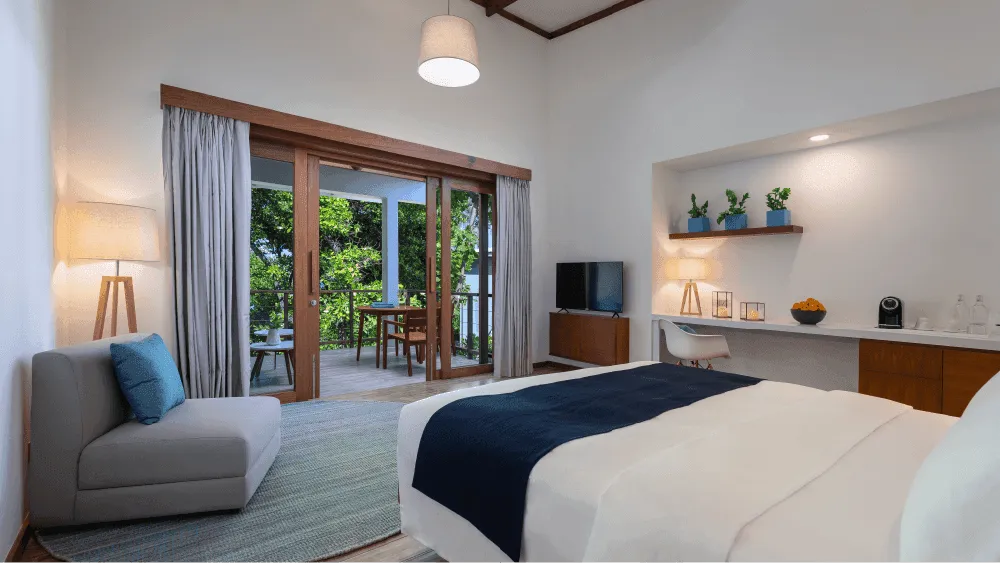 The bedroom with its bed and doors towards the balcony.
