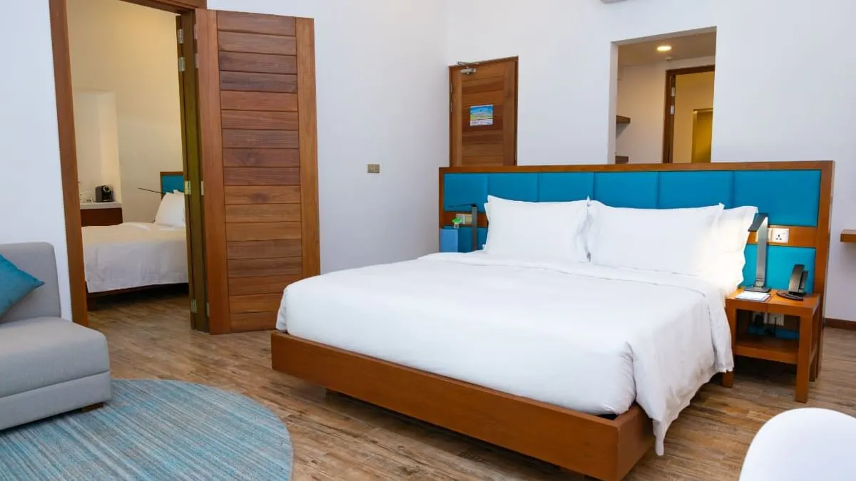 The bedroom with a bed, sofa and wooden furniture.