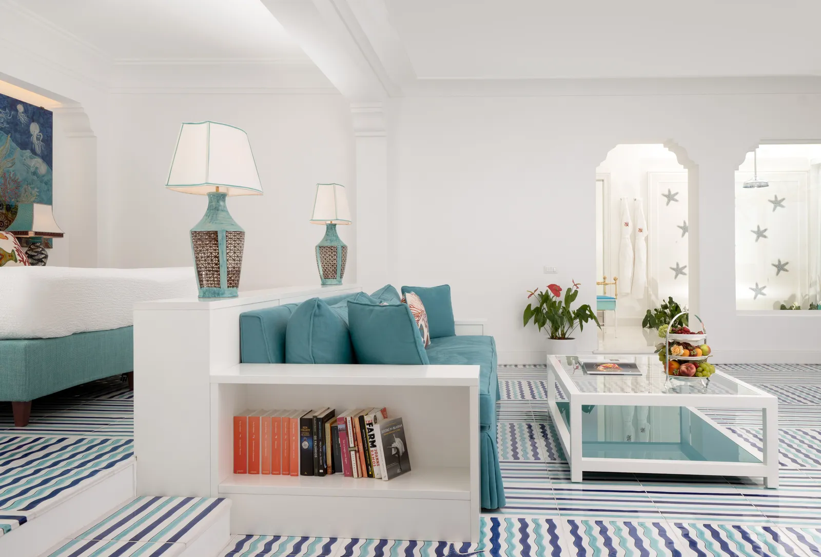 The living room of the Virginia Suite, with a turquoise sofa, ceramic lamps and a wave-patterned majolica floor.