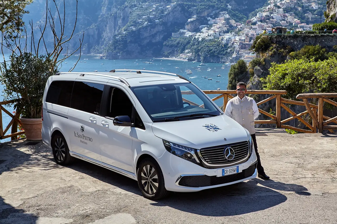 The hotel’s shuttle, a white van with the San Pietro crest, parked at a viewpoint facing Positano.