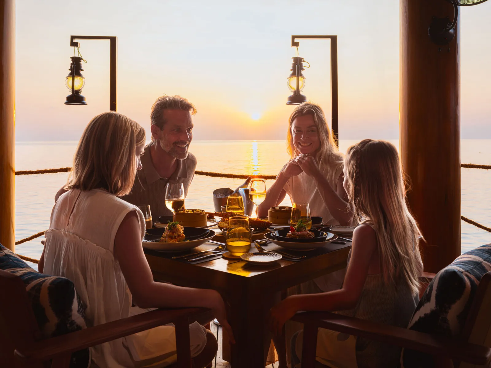 A family at dinner at Fish Market at sunset, among the lanterns.