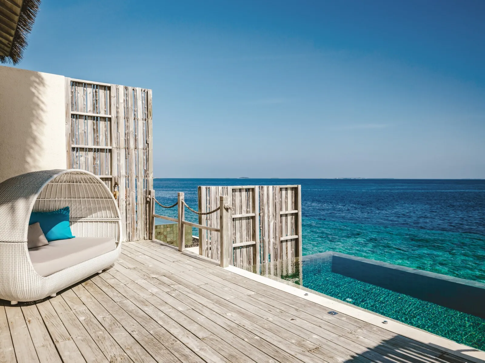 A One Bedroom Lagoon Pool Villa’s deck: the cocoon daybed, the infinity pool and the ocean.
