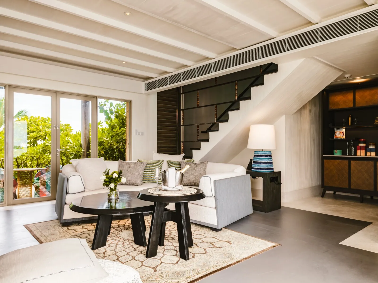 A One Bedroom Sunset Lagoon Pool Villa’s sitting room, with the stairs up to the bedroom.