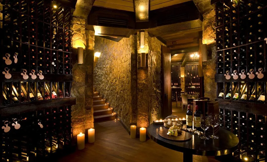 Wine racks and a table among the stone walls of The Cellar.