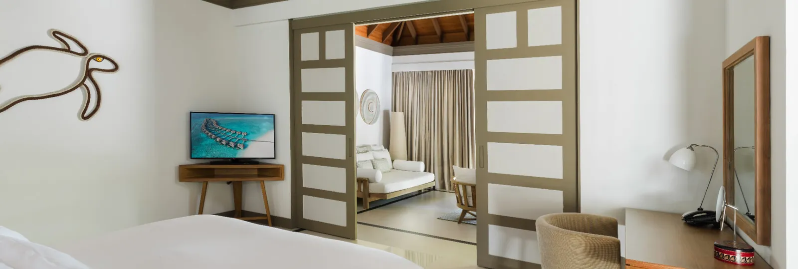 The Deluxe Family villa bedroom with a doorway towards the sitting room.