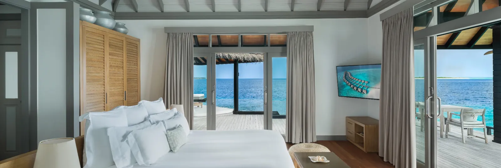A Grand Ocean Residence bed facing the ocean and deck.