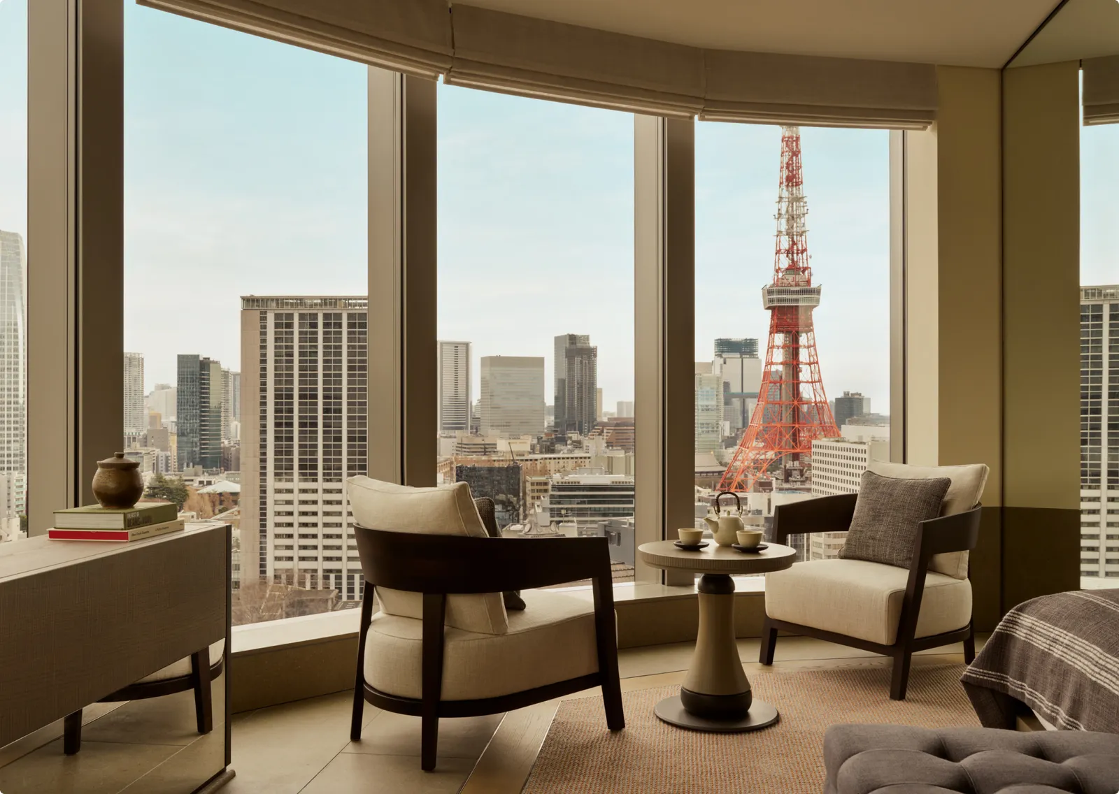 A Corner Suite’s curved window, 2 armchairs and Tokyo Tower on the right.