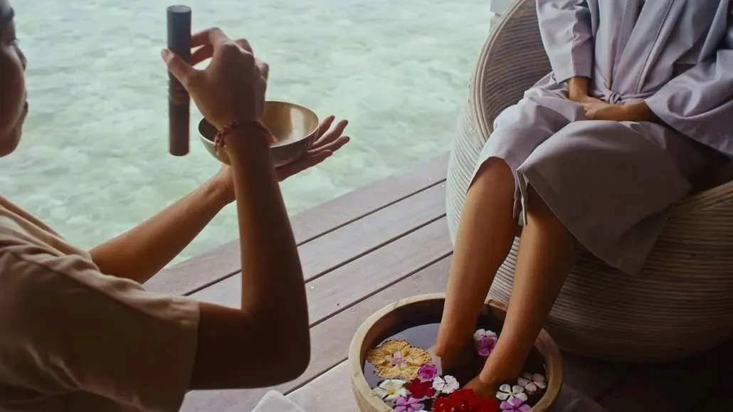 A flower footbath and a singing bowl at the overwater spa
