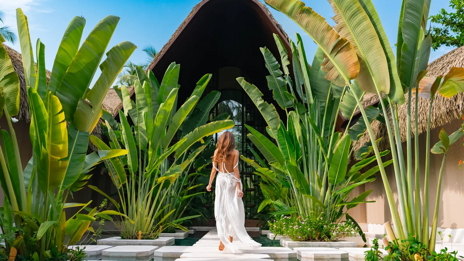 A guest on a path through the plants, under a pointed roof