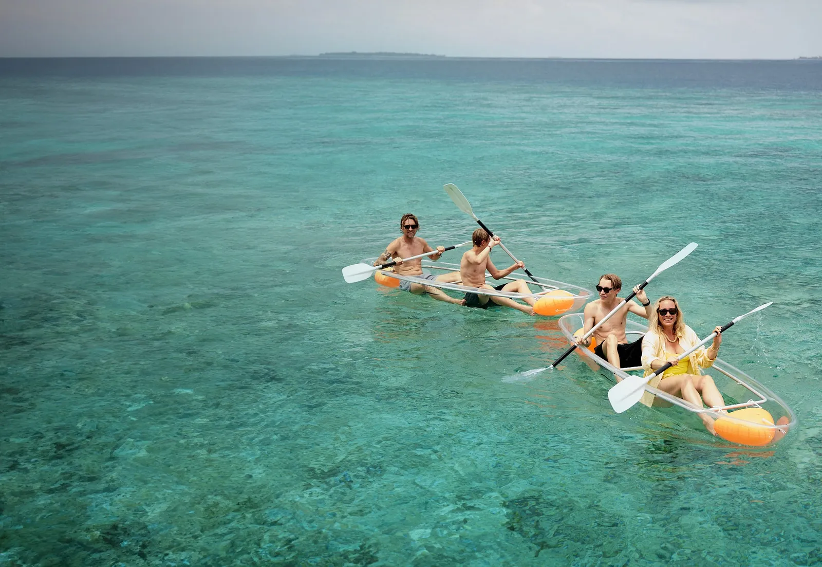 Guests in clear kayaks on the lagoon