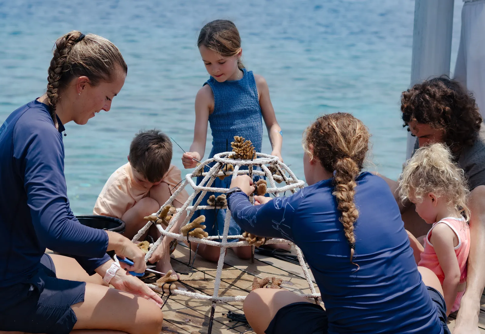 Children building a coral frame with an instructor