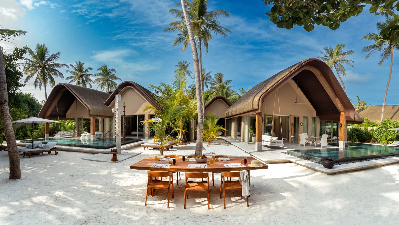 The Four Bedroom Beach Residence with Two Pools from outside, a table on the sand