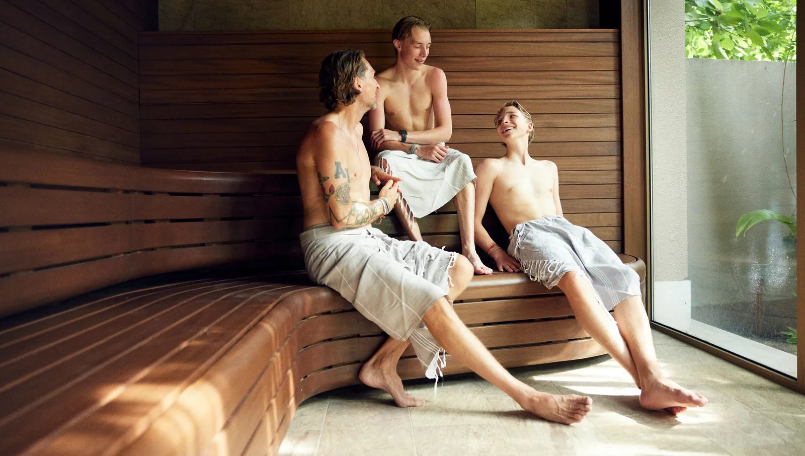 3 guests in the sauna on its wooden benches