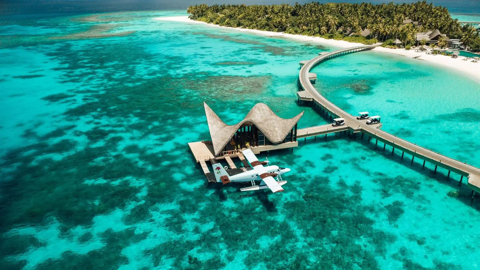 The arrival jetty over turquoise water, the water villas beside it