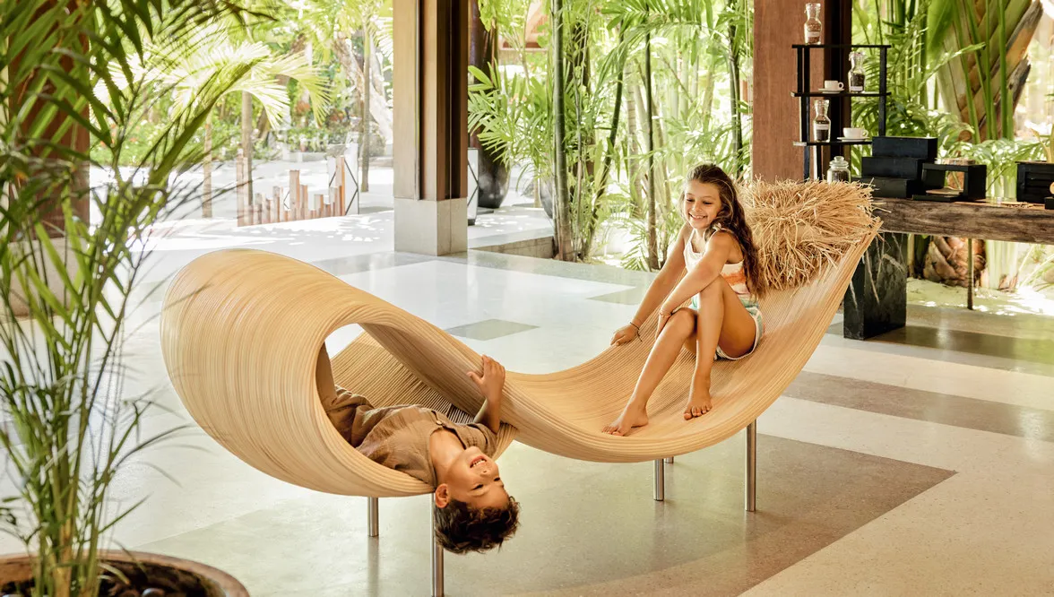 A mother and child on a sculptural lounger in the lobby