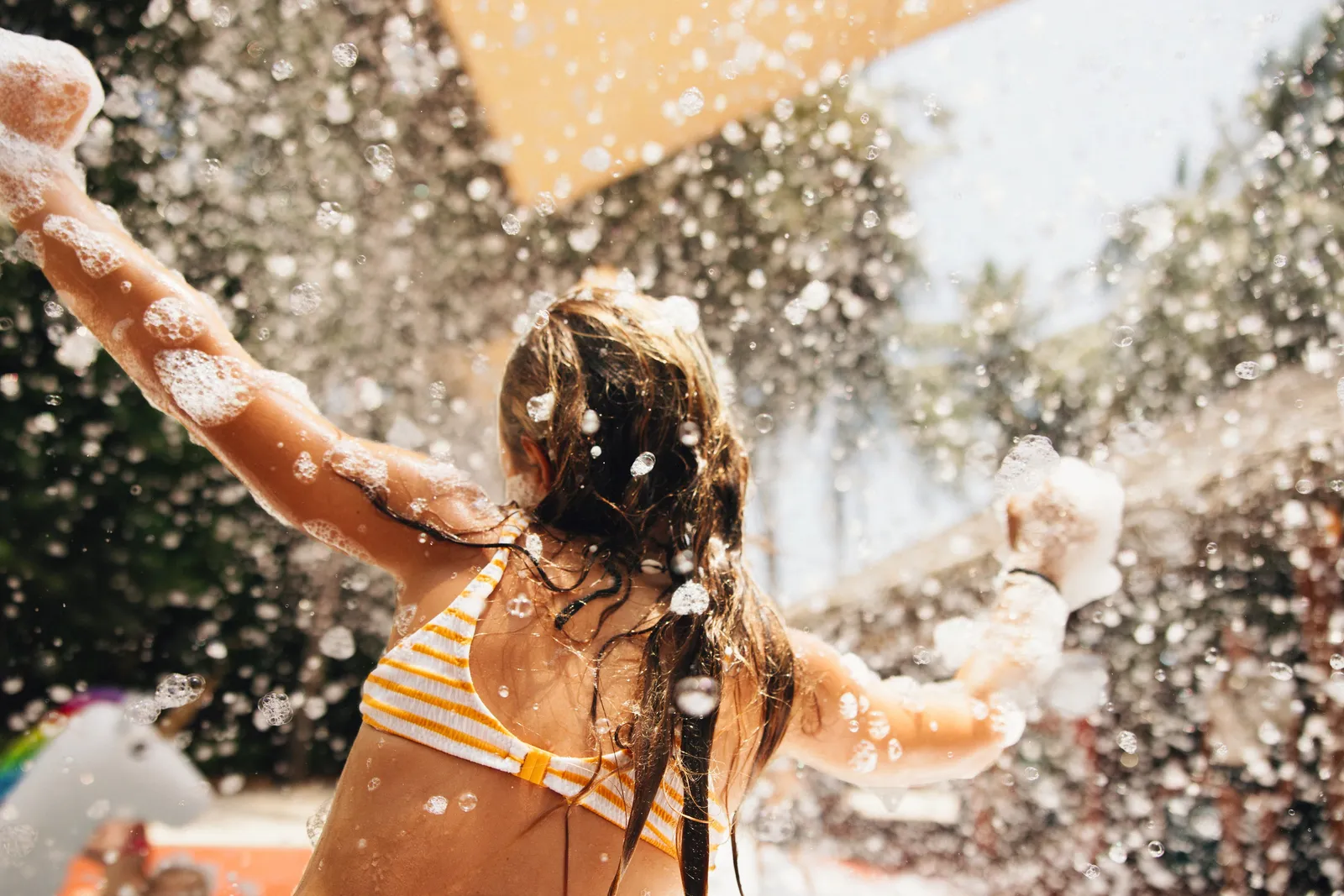 A girl playing among foam and bubbles
