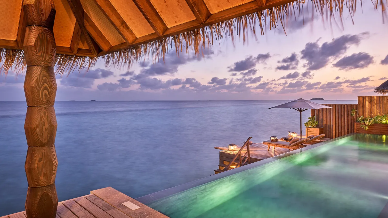 A Luxury Sunset Water Villa with Pool’s deck at sunset