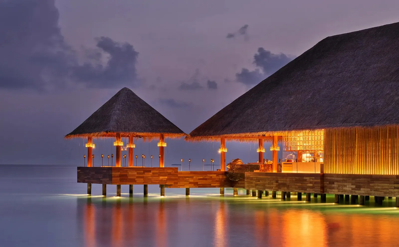 Saoke over the water at dusk, its lights on
