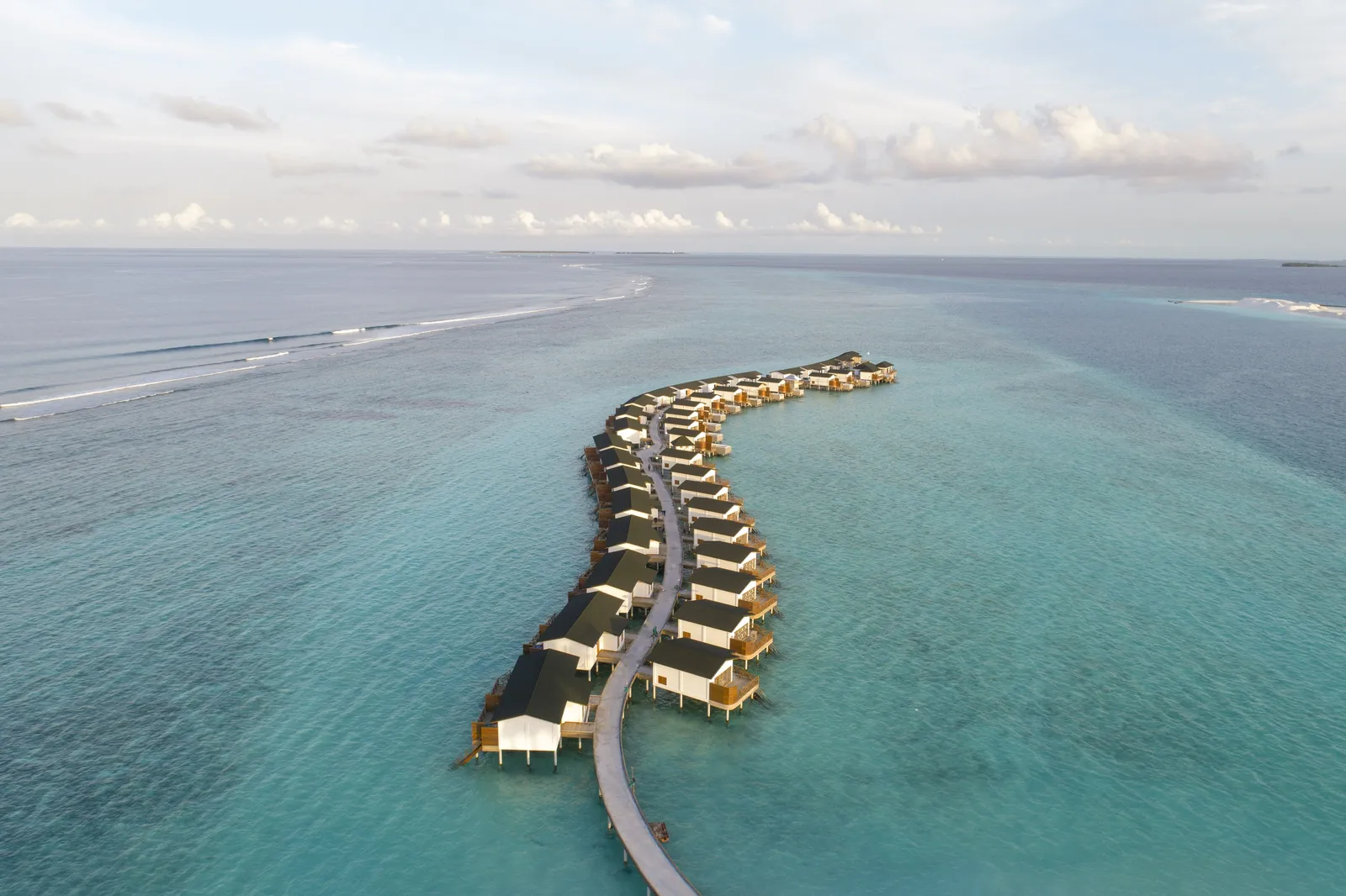 The lagoon villas in a line along the curving boardwalk, over turquoise water