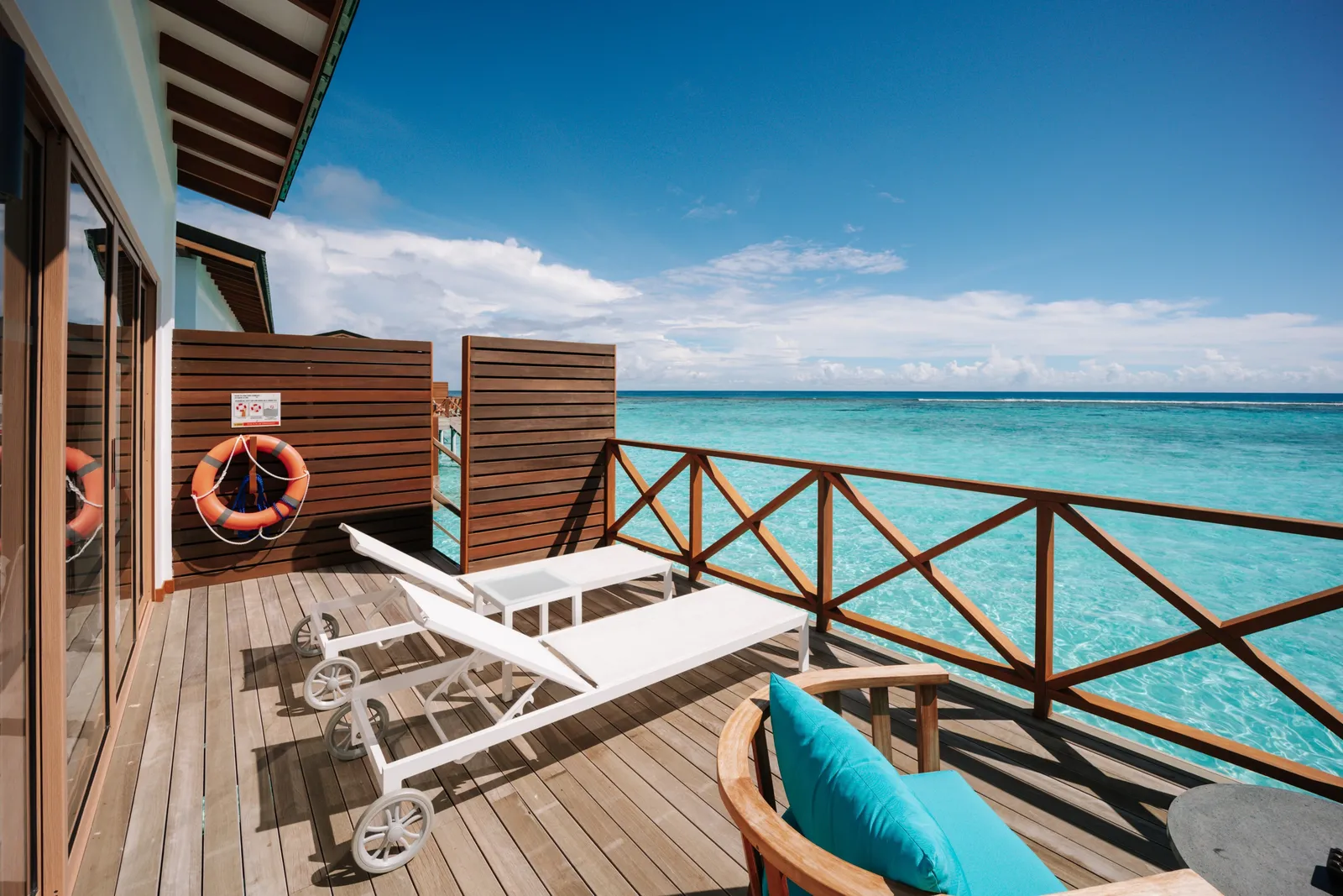 A Lagoon Villa’s deck with 2 loungers and a lifebuoy, above the lagoon